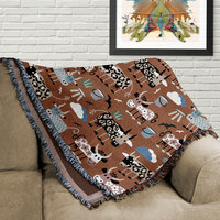 Whimsical Cows Woven Cotton Blanket, folded on a couch