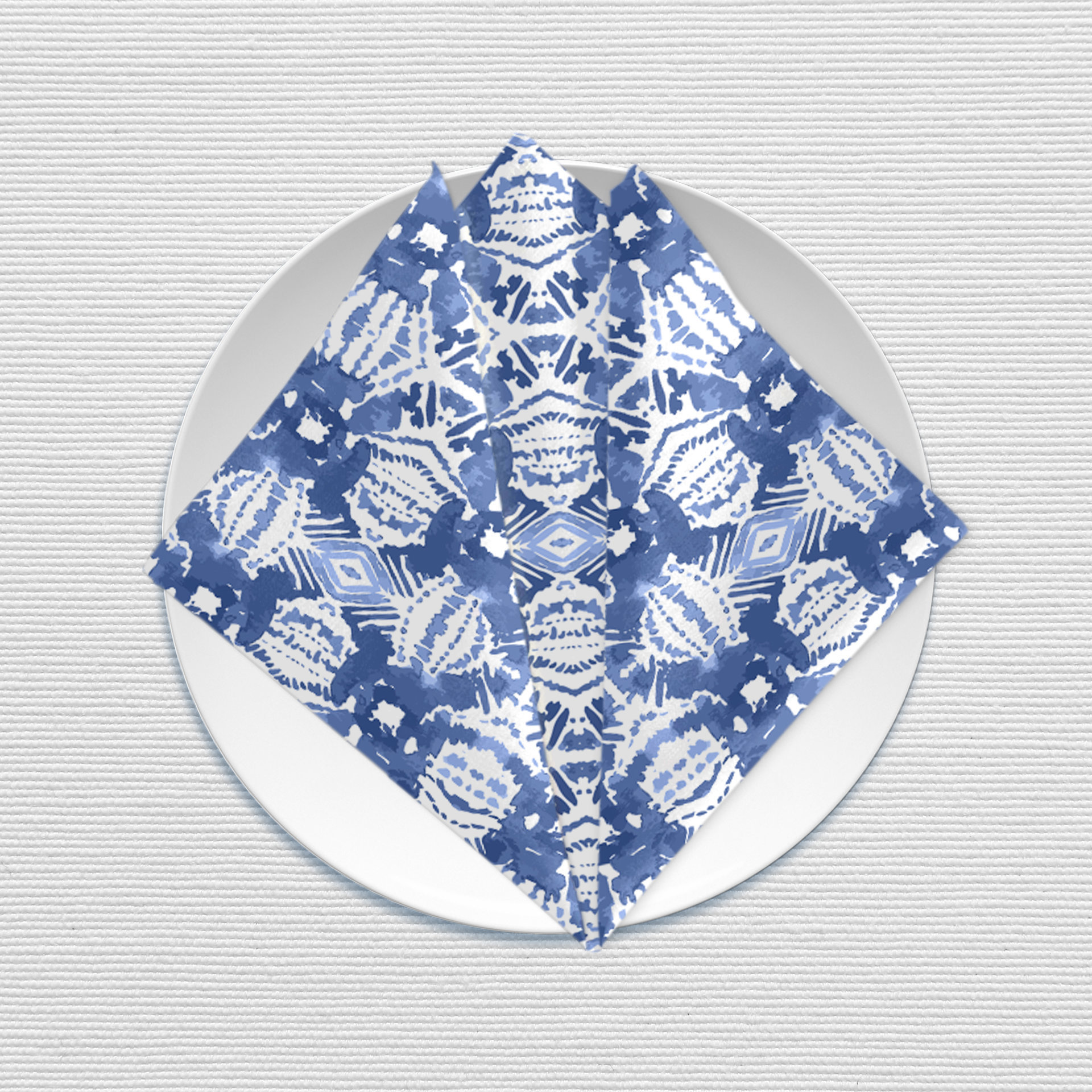 Blue Ikat Pattern Cotton Napkin, folded on a plate